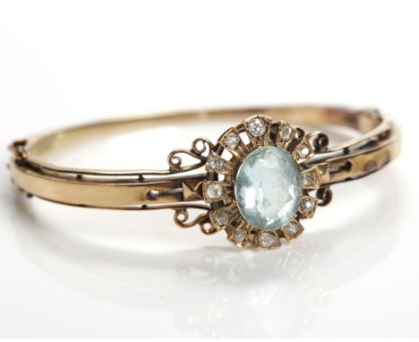 VICTORIAN AQUAMARINE AND DIAMOND BANGLE
with a large oval aquamarine measuring approximately 12.2mm x 10.1mm, surrounded by o