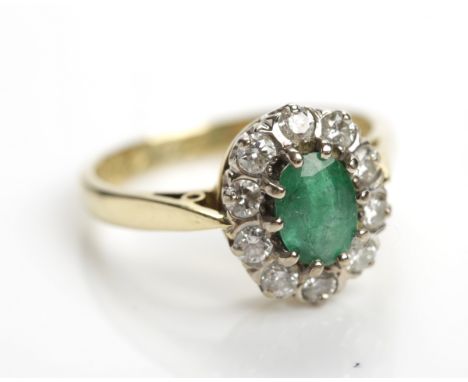 EMERALD AND DIAMOND CLUSTER RING
set centrally with an oval emerald approximately 5.8mm x 3.9mm, surrounded by a row of brill