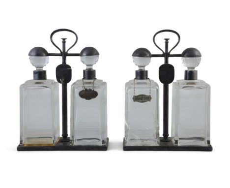 A PAIR OF SPIN TOP DOUBLE DECANTER TANTALUS BY HUKIN & HEATH each carrying frame with locking mechanism holding two decanters
