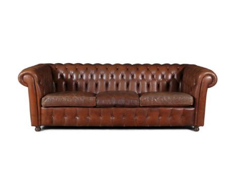 A CHESTERFIELD BUTTON BACK THREE SEATER SOFA,upholstered in brown leather with scroll-end arms, detachable seat cushions and 