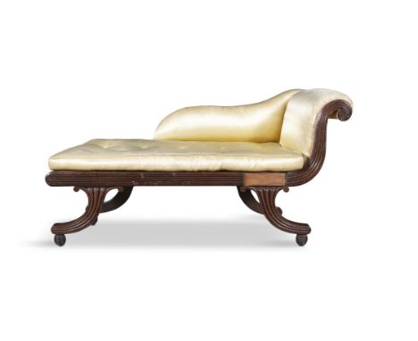 A COMPACT MAHOGANY AND SILK UPHOLSTERED CHAISE LONGUE 19TH CENTURY of classical design with raised scroll end fitted with but