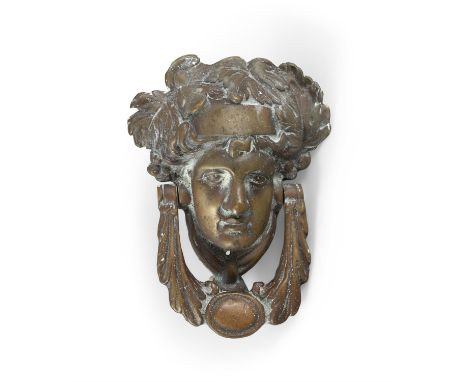 A GEORGIAN STYLE BRASS DOOR KNOCKER IN THE FORM OF A CLASSICAL FEMALE MASK,with leaf sing handle, 20cm high