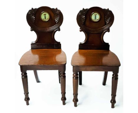 HALL CHAIRS, a pair, early 19th century William IV mahogany each with scroll carved back with heraldic escutcheon and panel s