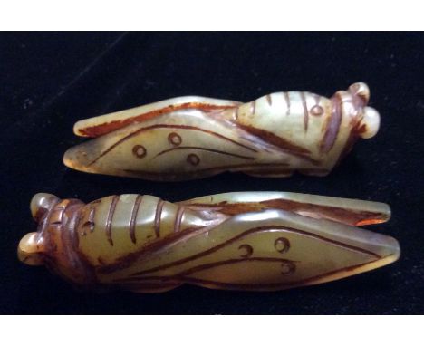 A PAIR OF ORIENTAL JADE CARVINGS OF GRASSHOPPERS Having elongated wings, textured bodies and bulbous eyes. (approx 8.5cm)