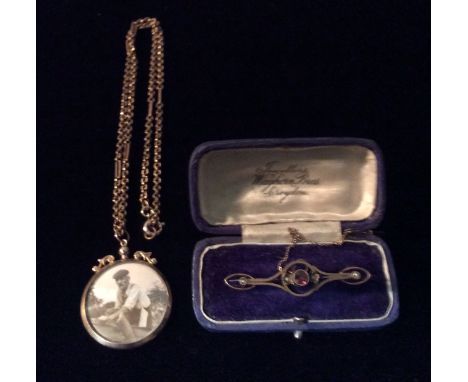 AN EDWARDIAN 9CT GOLD AMETHYST AND SEED PEARL BAR BROOCH The single amethyst flanked by two seed pearls in an elliptical sett