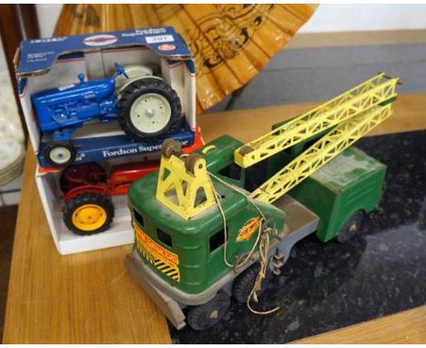 A Louis Marx mobile crane truck, finished in green and yellow tinplate and two diecast tractors