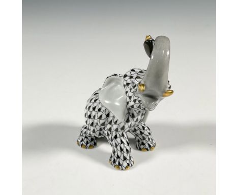 A small figure of an elephant with its trunk curled up in the air. Decorated in a black scale pattern, and gilded accents to 