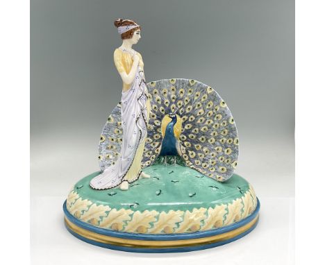 Striking bone china figural of a lady in a pale yellow and light violet dress standing next to a peacock with its tail feathe