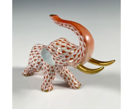 A small figure of an elephant with its trunk high in the air. Decorated in a red scale pattern, and gilded tusks. Herend back