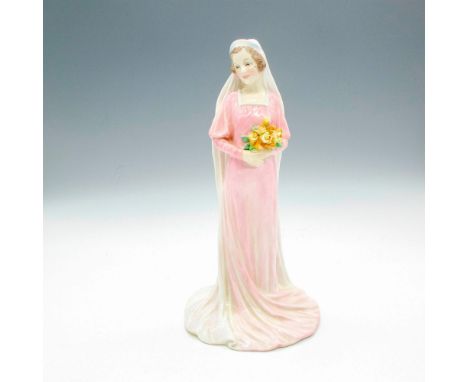 Glossy figurine wearing a classic 1930s inspired wedding gown in pale pink with white veil and holding a bouquet of orange an