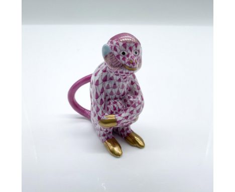 This monkey figurine features a pink hand painted fishnet pattern with gilded hands, feet, and facial features. Herend hallma