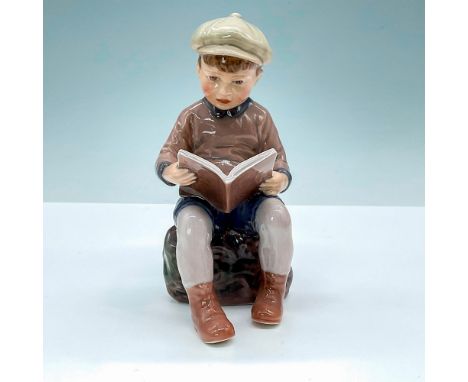 Dahl Jensen figurine of reading boy. DJ Copenhagen backstamp. Artist: Jens Peter Dahl JensenIssued: 20th CenturyDimensions: 3