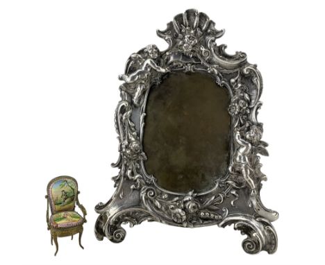 19th/ early 20th century silver-plated picture frame, cast with Putti, flower garlands and shell motifs on two scroll feet, w