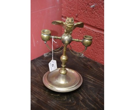 A pair of 19th century silvered and gilt novelty candelabra, each crested by an owl  perched on a ball, the hinged head enclo
