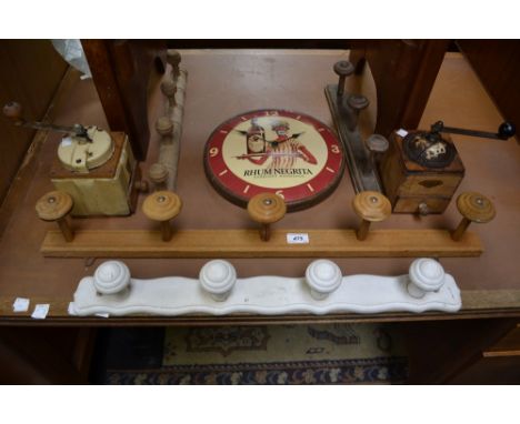 An enamelled coffee grinder; another; an advertising Rhum Negrita wall clock; four wall mounted cloak racks. (7)