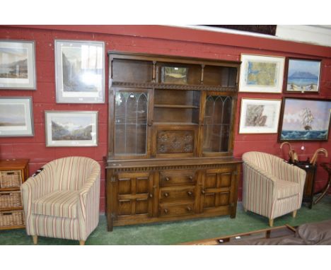 A Priory style oak dresser, recess over shelving, fall front cabinet and glazed door cupboards to top, three drawers flanked 