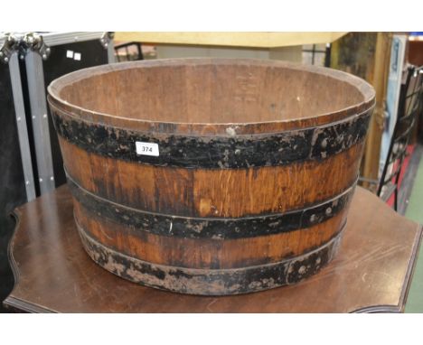 An oak planter made from a coopered barrel.