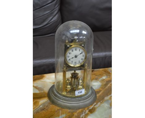 A brass 90 day anniversary clock, under glass dome