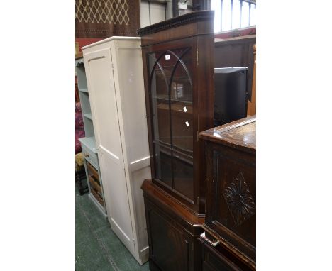 A mahogany floor standing corner display cabinet, canted angles, astragal glazed door to top, panel door to base