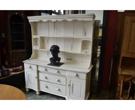 A Victorian painted pine dresser, two shelves, drawers and recess to top, inverted breakfront base, three graduated long draw