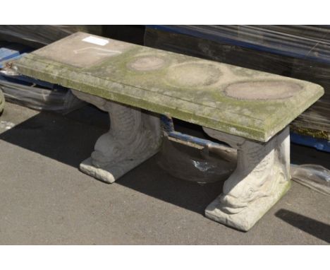 A reconstituted stone garden bench, stylized fish supports.