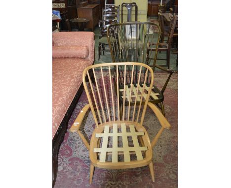 An Ercol pale wood wing arm chair; another similar dark wood (2)