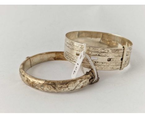 A wide silver buckle bangle and one other