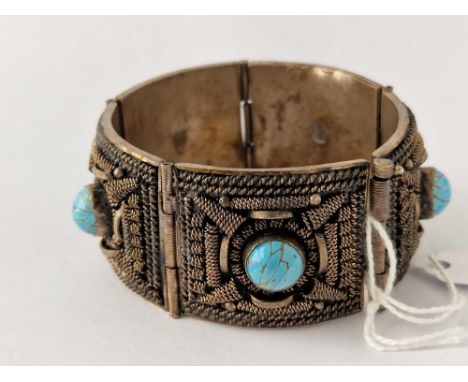 A hand made five panel decorated bangle each ornate panel with central turquoise matrix bead
