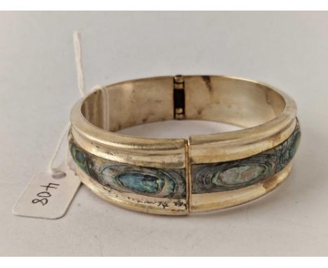 A good wide hinged silver bangle decorated with central abalone panel