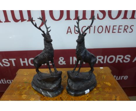 A pair of bronze stags mounted on a marble socle