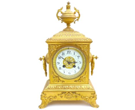 A French 19th century gilt metal mantel clock, with eight day movement, Arabic dial, decorative urn finial, raised upon four 