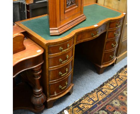 A Georgian style mahogany serpentine kneehole desk, leather inset, arrangement of nine drawers, bracket supports