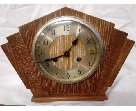An Art Deco oak cases striking mantel clock.