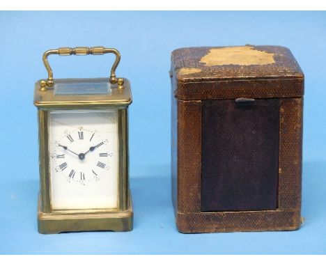 An early 20thC gilt brass Carriage Clock, the case a somewhat serpentine shape, with Roman numeric dial, the back impressed w