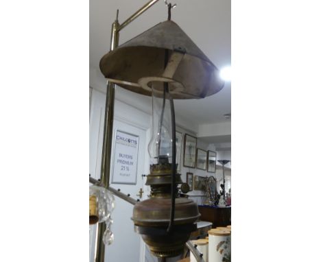 An early 20thC Railway brass Lamp, the glass chimney encased with metal surrounds and large carry handle, 25in (64cm) long.
