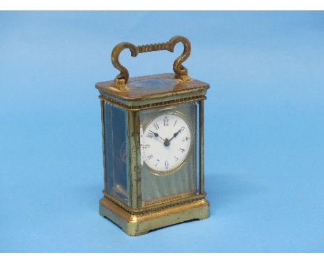 An early 20th century French gilt brass Carriage Clock, of five glass form with hinged carry handle, 8-day movement, the circ