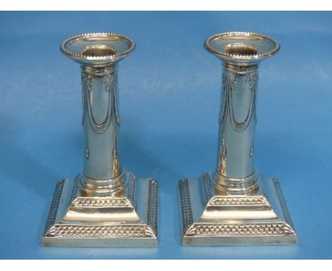 A pair of Edwardian silver Candlesticks, by Thomas Bradbury &amp; Sons Ltd., hallmarked Sheffield, 1901, the square stepped b