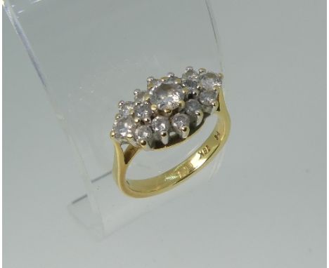 A diamond Dress Ring, the central stone c.¼ct, with a smaller diamond on each side, all within a border of twelve further sto