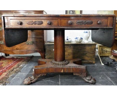 A Regency rosewood Sofa Table, the table with drop-flap ends and bead moulded edge, on two frieze drawers, with foliate motif