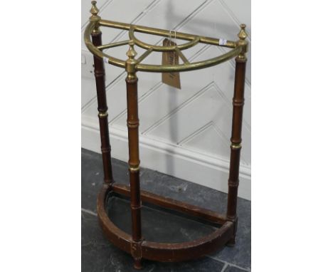 An early 20thC brass and mahogany Stick Stand, the fan-shaped brass top raised on mahogany and brass ringed legs, 15½in (40cm