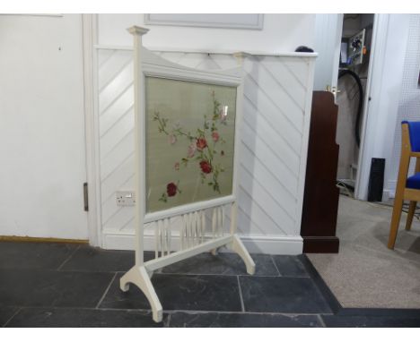 An Arts and Crafts white-painted Fire Screen, the wooden frame enclosing the glazed tapestry work panel, raised on sledge fee