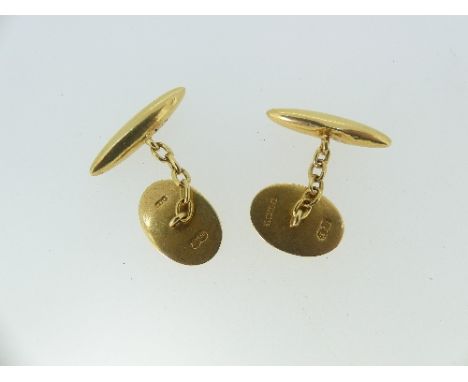 A pair of 18ct yellow gold Cufflinks, the oval fronts with engine turned decoration, torpedo reverses, some dents, with chain
