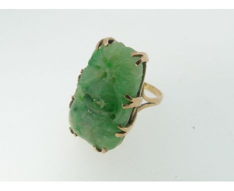 A carved jade Ring, mounted in unmarked rose coloured mount, tested as 9ct gold, Size M, the jade 2.8mm long, cracked.