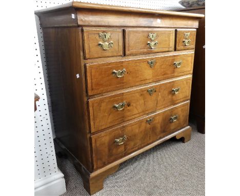 An early Georgian walnut Chest of Drawers, the cross-banded top with feathering border, above three short above three long dr