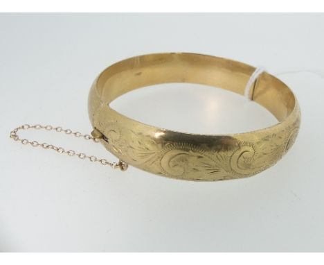 A 9ct yellow gold hollow hinged Bangle, the front foliate engraved, approx weight 15.2g, some damage.
