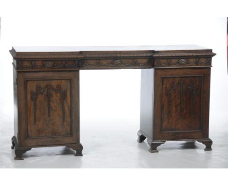 A late 19th century mahogany pedestal sideboard, the inverted breakfront with a leaf carved border above three frieze drawers