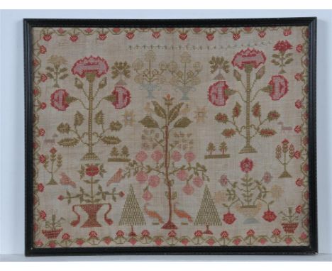 A needlework sampler 19th century work with a tree of life vase of blooms within a strawberry pattern border framed. 33 x 41 