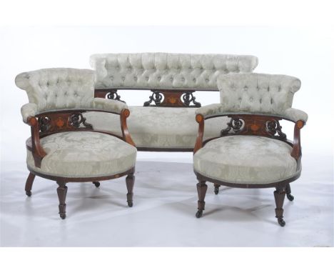 A Victorian three piece Rosewood and mahogany and inlaid drawing room suite, the settee with a curvilinear padded and button 