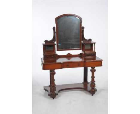 A Victorian mahogany inverted breakfront Duchesse dressing table, the shaped mirror enclosed by leafy lyre shape supports abo