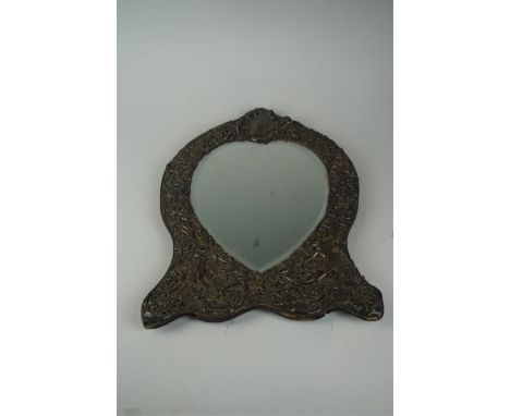 A late Victorian hallmarked silver easel dressing table mirror repoussé decorated with cherubs and foliate surrounding a vaca